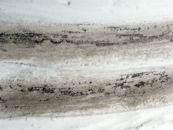 Road texture with thin layer of snow on surface and dark tire marks.